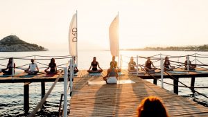 a group of people sitting on a dock by the water